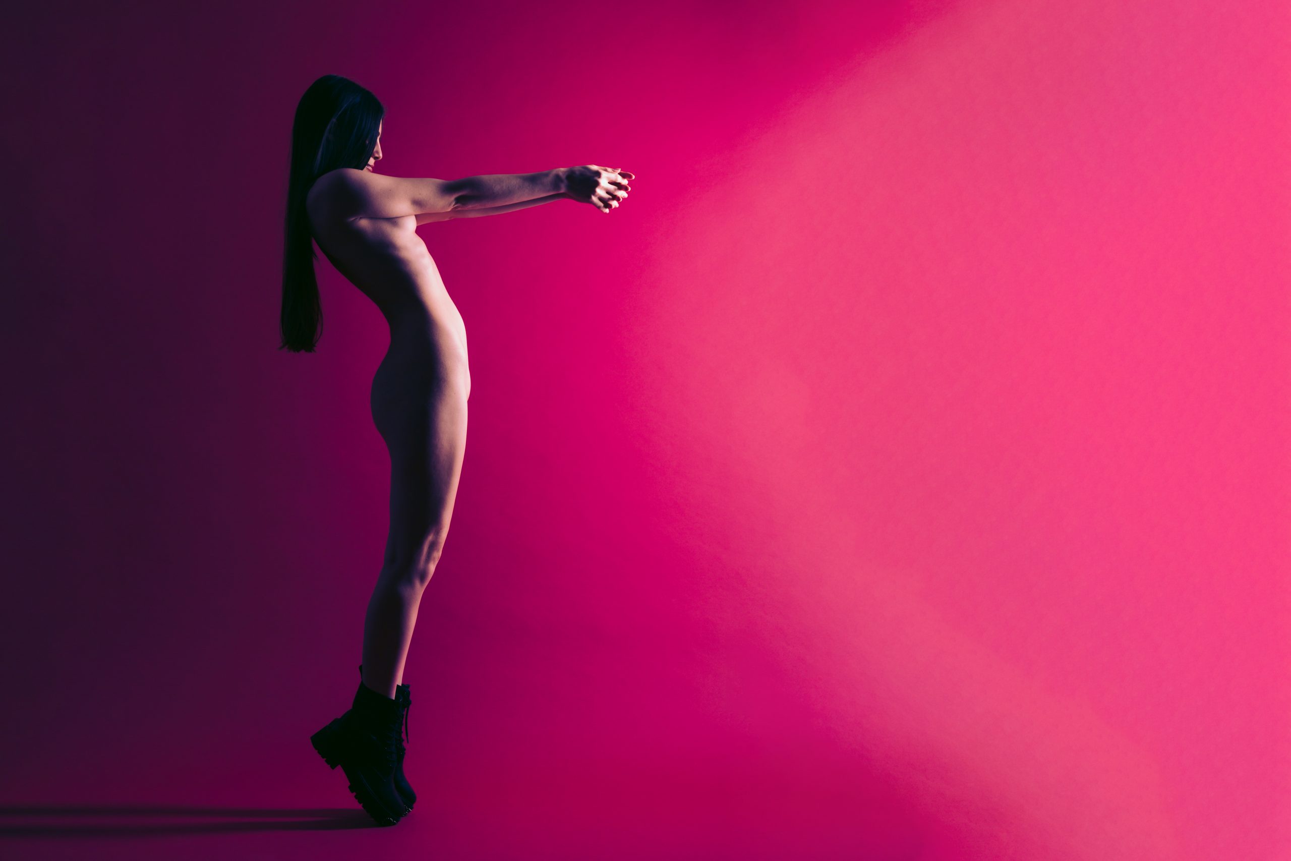 Standing nude in front of red-violet background